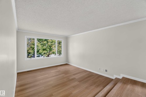 Wood-finish flooring, white trim, and a multi-pane window - 14725 43A Avenue Nw, Edmonton, AB - Indoor Photo Showing Other Room