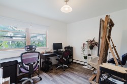 Naturally lit room featuring wood-finish flooring, white walls, and a large window with white blinds - 