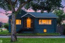 Deep teal exterior with white trim, featuring a dark wood front door, wrought iron railing - 8759 78 Avenue Nw, Edmonton, AB  - Outdoor 