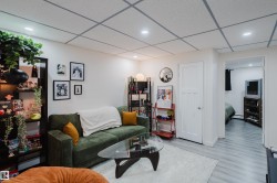 Recessed lighting illuminating the living area with light wood-finish flooring - 