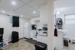 Compact kitchen area featuring white cabinetry, a stainless steel sink, and a window for natural light - 