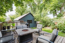 Expansive wood-decked patio featuring a built-in fire pit - 