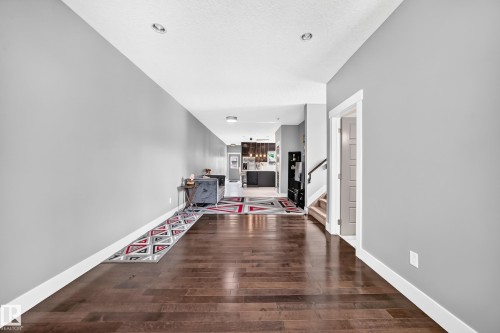 Hardwood flooring throughout, recessed ceiling lighting, light gray wall paint, white trim, and a visible doorway - 12730 118 Street Nw, Edmonton, AB - Indoor Photo Showing Other Room