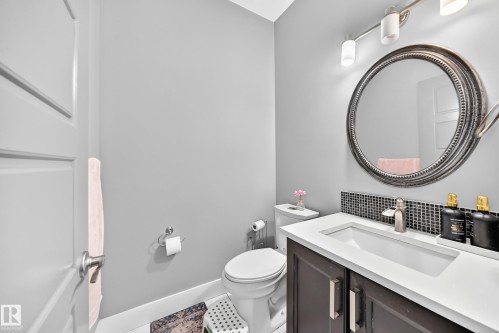 Dark wood-finish vanity with a white countertop and integrated rectangular sink - 12730 118 Street Nw, Edmonton, AB - Indoor Photo Showing Bathroom