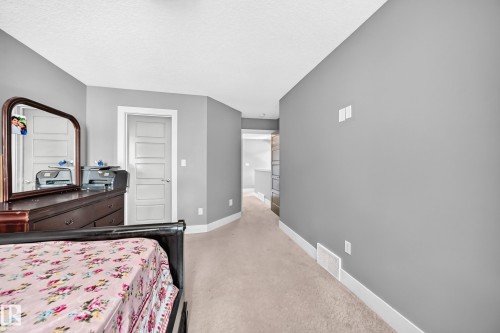 Neutral wall finishes with white trim, carpeting, and a contrasting door - 12730 118 Street Nw, Edmonton, AB - Indoor Photo Showing Bedroom