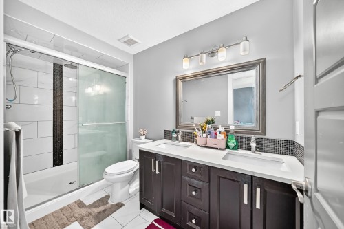 Dual vanity with undermount sinks and dark wood cabinetry - 12730 118 Street Nw, Edmonton, AB - Indoor Photo Showing Bathroom