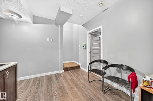 Wood-finish flooring, light gray wall tones, paneled interior door, built-in cabinetry with light-toned countertop - 12730 118 Street Nw, Edmonton, AB - Indoor