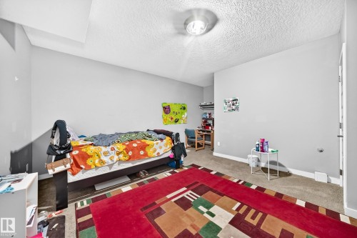 Light gray painted walls with white trim, textured ceiling, and recessed lighting - 12730 118 Street Nw, Edmonton, AB - Indoor Photo Showing Bedroom