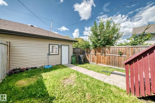 Rear yard featuring a detached structure with siding, a shingle roof, and a wood privacy fence - 12730 118 Street Nw, Edmonton, AB - Outdoor