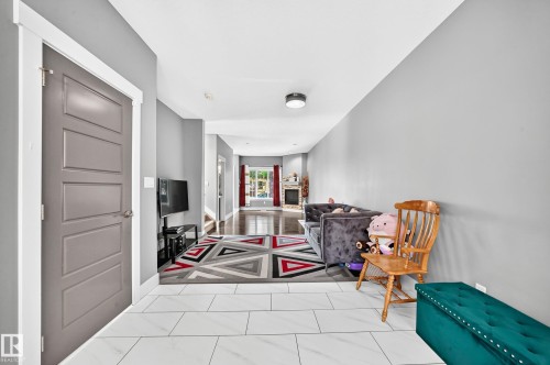 Recessed lighting illuminates the entryway, featuring large format tile flooring and a five-panel interior door - 12730 118 Street Nw, Edmonton, AB - Indoor Photo Showing Other Room