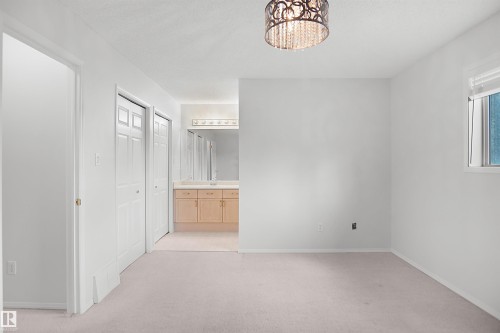 Recessed window with white trim, two panel doors, and a decorative semi-flush mount light fixture - 907 Jordan Crescent Nw, Edmonton, AB - Indoor Photo Showing Other Room