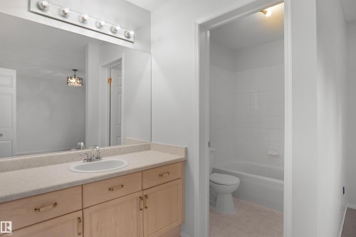 Spacious vanity featuring an integrated sink, polished chrome faucet, and ample storage cabinetry - 907 Jordan Crescent Nw, Edmonton, AB - Indoor Photo Showing Bathroom