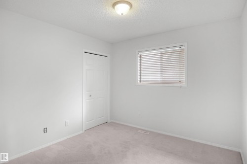Soft carpet flooring, neutral wall finishes, window with blinds, bi-fold closet door, and ceiling-mounted light fixture - 907 Jordan Crescent Nw, Edmonton, AB - Indoor Photo Showing Other Room