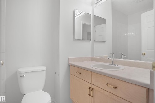 Light-toned vanity with an integrated sink and chrome faucet - 907 Jordan Crescent Nw, Edmonton, AB - Indoor Photo Showing Bathroom