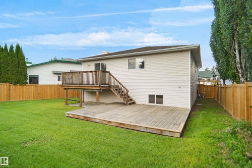 Expansive backyard with a manicured lawn, wood fencing, and mature trees - 907 Jordan Crescent Nw, Edmonton, AB - Outdoor With Deck Patio Veranda