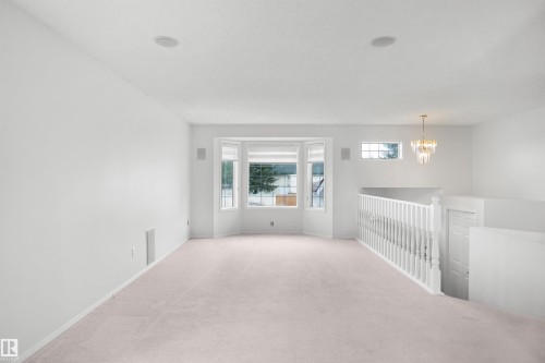 Bay window, ceiling-mounted chandelier, recessed lighting, carpet flooring, and white painted walls - 907 Jordan Crescent Nw, Edmonton, AB - Indoor Photo Showing Other Room