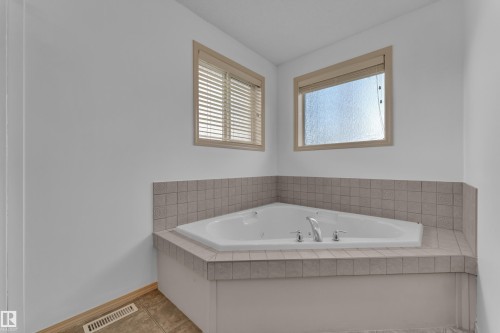 Corner jetted jacuzzi tub with tile surround, dual windows, and separate shower. - 14031 136 Street Nw, Edmonton, AB - Indoor Photo Showing Bathroom