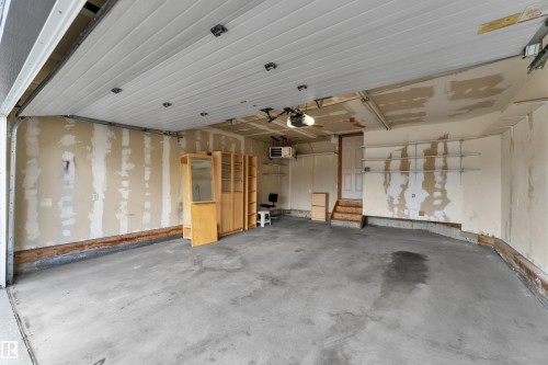 Double car garage, drywalled, with heater, shelving, and seller is willing to include the cabinetry shown here for the office space! - 14031 136 Street Nw, Edmonton, AB - Indoor Photo Showing Garage