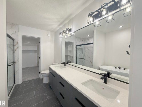 Dual vanity with quartz countertops and integrated rectangular sinks - 3158 Magpie Way Nw, Edmonton, AB - Indoor Photo Showing Bathroom