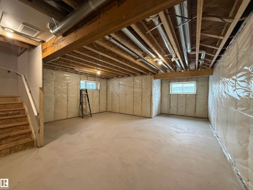 Unfinished lower level with exposed ceiling joists and ductwork, featuring multiple windows for natural illumination and insulated walls - 3158 Magpie Way Nw, Edmonton, AB - Indoor Photo Showing Basement
