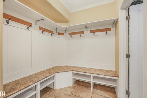 Built-in mudroom bench with integrated shelving, storage cubbies, and overhead coat hooks - 27 Kingdom Place, Leduc, AB - Indoor With Storage