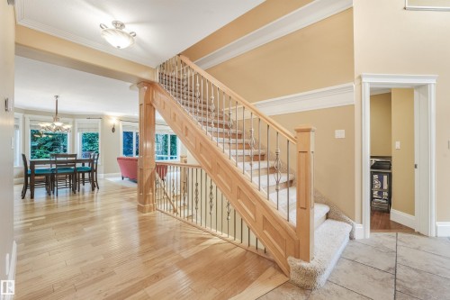 Hardwood flooring, tile flooring, carpeted staircase with wood banister and wrought iron spindles, recessed lighting, and crown molding - 27 Kingdom Place, Leduc, AB - Indoor Photo Showing Other Room