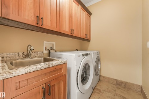 Light wood cabinetry with dark hardware - 27 Kingdom Place, Leduc, AB - Indoor Photo Showing Laundry Room