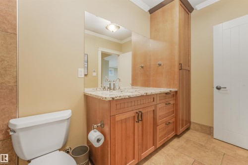 Wood-finish vanity with granite countertop and dual undermount sinks - 27 Kingdom Place, Leduc, AB - Indoor Photo Showing Bathroom