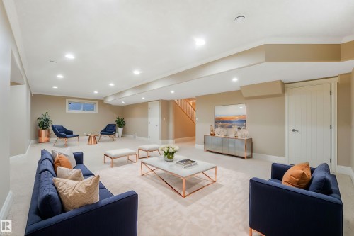 Spacious recreation room featuring recessed lighting, a window, and light-colored carpeting - 27 Kingdom Place, Leduc, AB - Indoor