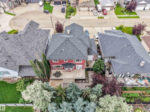Expansive rear deck, mature trees, tiered landscaping, stone steps, and dark shingle roofing - 27 Kingdom Place, Leduc, AB - Outdoor