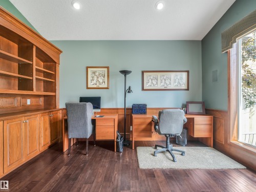 Built-in wood cabinetry with shelving, wood-finish flooring, recessed lighting, and a large window with wood trim - 967 Lamb Crescent Nw, Edmonton, AB - Indoor Photo Showing Office