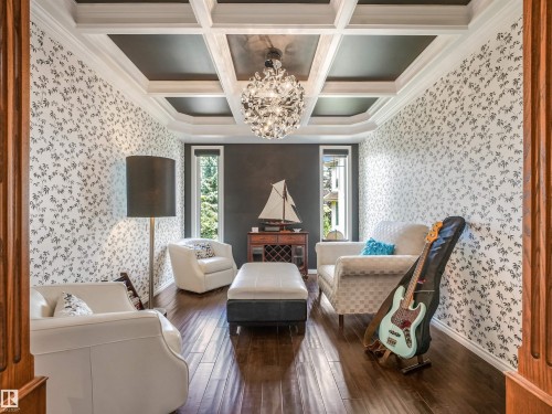 Coffered ceiling, decorative chandelier, wood-finish flooring, patterned accent wall, and natural light from window - 967 Lamb Crescent Nw, Edmonton, AB - Indoor