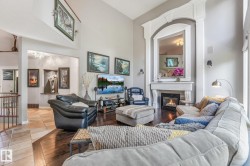 Vaulted ceiling, decorative fireplace with mantel, dark wood-finish flooring, recessed wall niche, and wrought iron railing - 