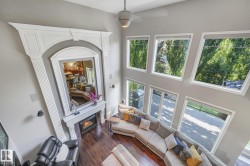 Vaulted ceilings with a ceiling fan, a gas fireplace with a decorative mantel and hearth, and wood-finish flooring - 
