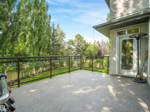 Spacious outdoor deck with a speckled surface, glass railings, and direct access to the interior - 967 Lamb Crescent Nw, Edmonton, AB - Outdoor