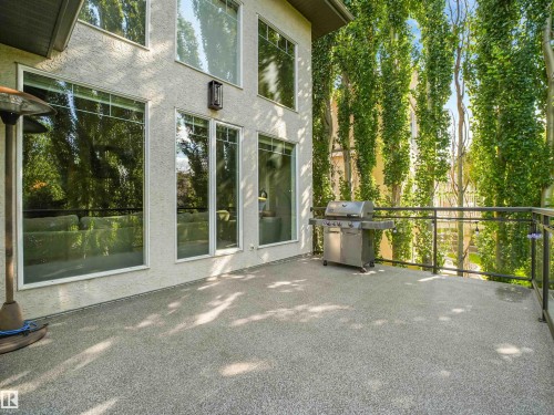 Expansive outdoor deck with textured surfacing and glass panel railings - 967 Lamb Crescent Nw, Edmonton, AB - Outdoor With Exterior