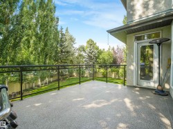 Spacious outdoor deck with a speckled surface, glass railings, and direct access to the interior - 