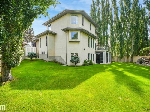 Expansive lawn featuring mature trees, a screened-in patio, and an upper-level balcony - 967 Lamb Crescent Nw, Edmonton, AB - Outdoor