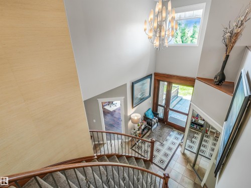 Two-story entryway with a vaulted ceiling, grand chandelier, and an arched transom window - 967 Lamb Crescent Nw, Edmonton, AB - Indoor Photo Showing Other Room