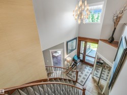 Two-story entryway with a vaulted ceiling, grand chandelier, and an arched transom window - 