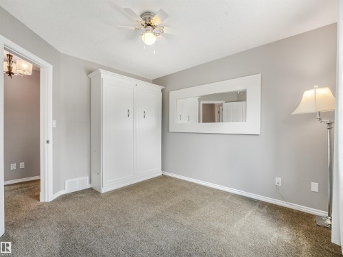 Built-in white cabinetry, ceiling fan with integrated lighting, and carpeted flooring - 967 Lamb Crescent Nw, Edmonton, AB - Indoor Photo Showing Other Room