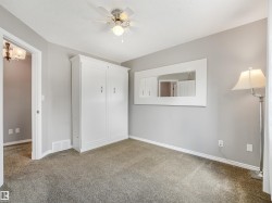 Built-in white cabinetry, ceiling fan with integrated lighting, and carpeted flooring - 