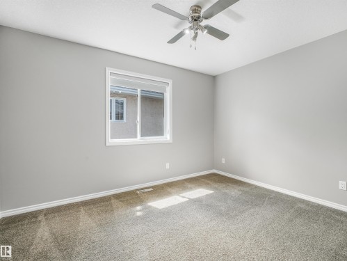 Neutral gray wall finish, white window trim, and a ceiling fan with integrated lighting - 967 Lamb Crescent Nw, Edmonton, AB - Indoor Photo Showing Other Room