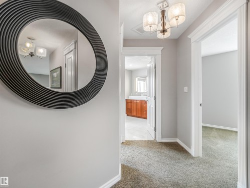 Hallway featuring neutral-toned walls, plush carpeting, and ornate light fixture - 967 Lamb Crescent Nw, Edmonton, AB - Indoor Photo Showing Other Room