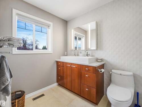 Wood-finish double vanity with a white countertop and dual vessel sinks - 967 Lamb Crescent Nw, Edmonton, AB - Indoor Photo Showing Bathroom
