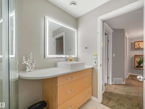 Wood-finish vanity with a white countertop and rectangular vessel sink - 967 Lamb Crescent Nw, Edmonton, AB - Indoor Photo Showing Bathroom