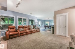 Expansive living area with neutral carpeting, recessed lighting, and multiple windows - 