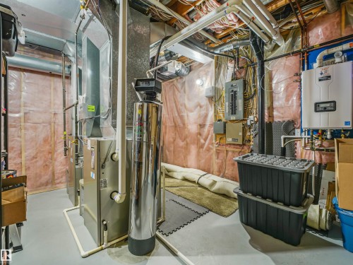 Utility area featuring a water heater, furnace, water treatment system, and exposed ceiling joists - 967 Lamb Crescent Nw, Edmonton, AB - Indoor Photo Showing Basement