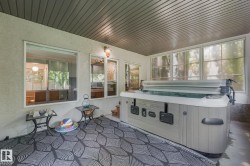 Covered patio with a built-in spa, multiple windows, and a textured ceiling - 