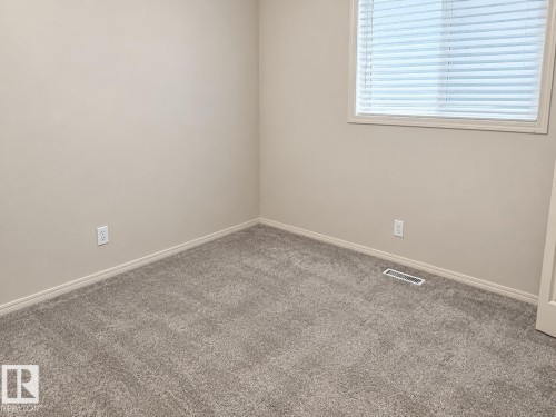 Neutral wall finishes with a window featuring horizontal blinds - 507 Wiseman Lane Nw, Edmonton, AB 